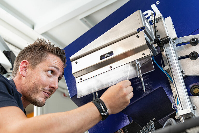 Foto: Gesco: Ein Mann in blauen Shirt bedient eine Maschinenanlage
