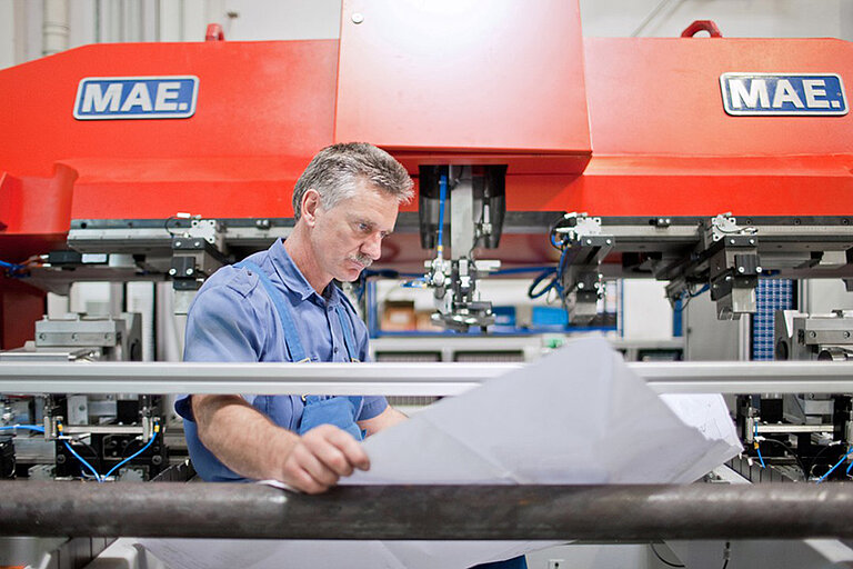 Foto: Gesco: Ein Mann arbeitet an einer grossen Maschine in einer Fabrik