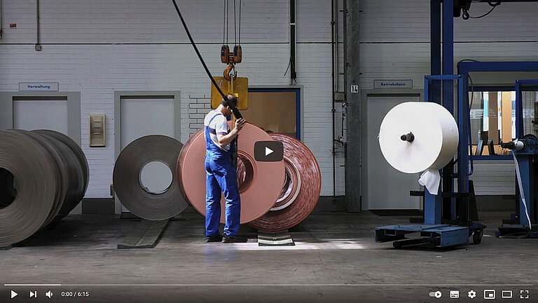 Foto: Gesco: Video Vorschaubild von einem Mann der in einer Fabrik ein grossen Metallhaken an der Decke navigiert