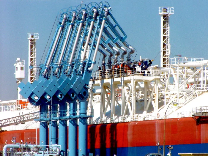 Foto: Gesco: Krahnarme verladen etwas auf ein großes Schiff